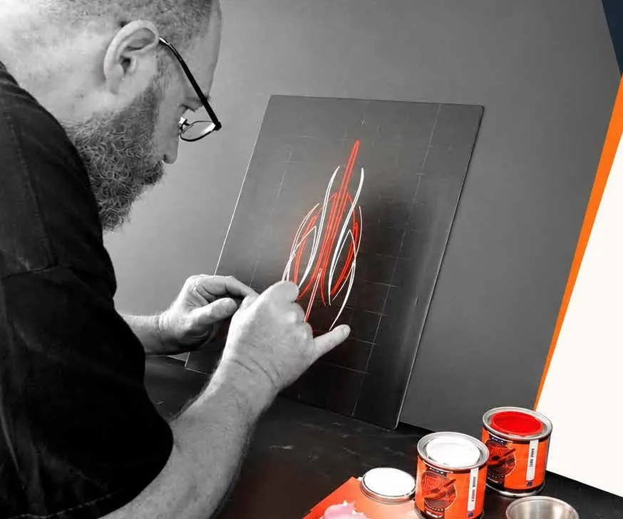 Pinstriper trazando filetes rojos con pincel